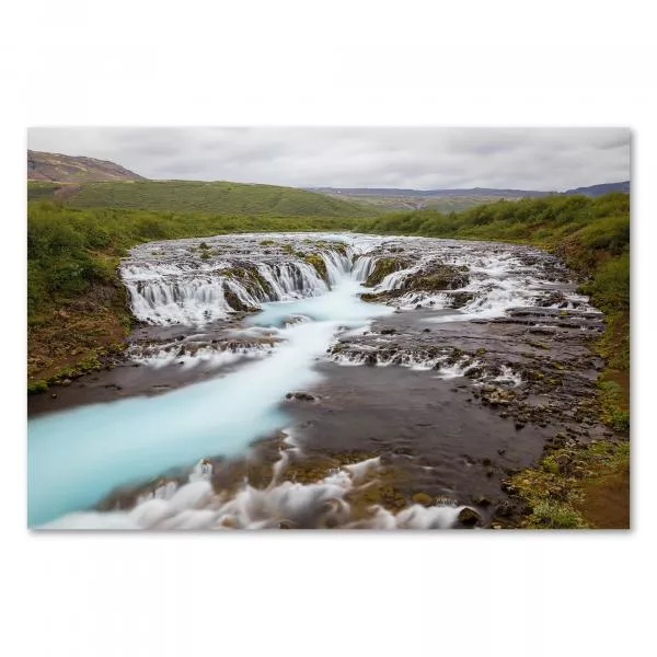 Blauer Fluss schlängelt sich durch grüne Landschaft Islands, Wasserfälle.