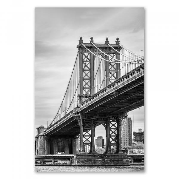 Die Brooklyn Bridge in New York City erhebt sich majestätisch. Die Schwarzweißfotografie betont die imposante Architektur und die filigrane Struktur der berühmten Brücke.