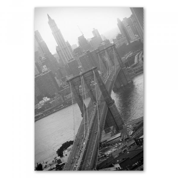 Schwarzweiß-Fotografie der Brooklyn Bridge in New York, umgeben von Wolkenkratzern.