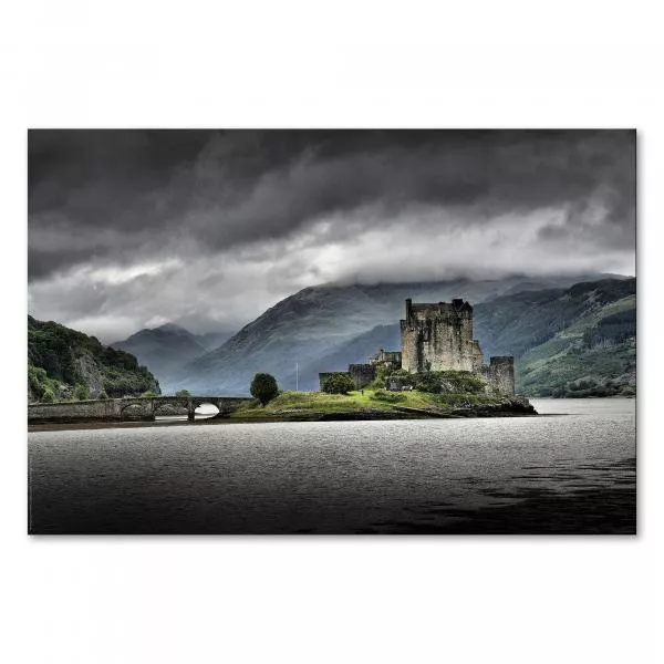 Eilean Donan Castle auf einer Insel, verbunden durch eine Steinbrücke, dramatisch unter dem Himmel.