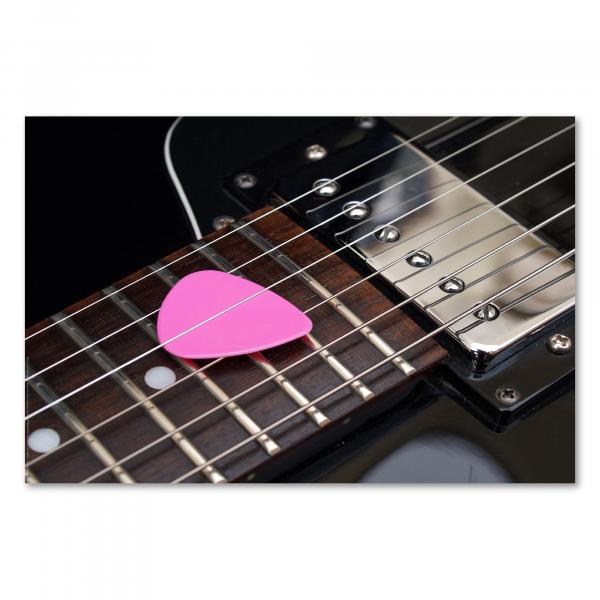 Nahaufnahme einer schwarzen E-Gitarre mit einem pinken Plektrum auf den Saiten - bereit zum Musik machen!