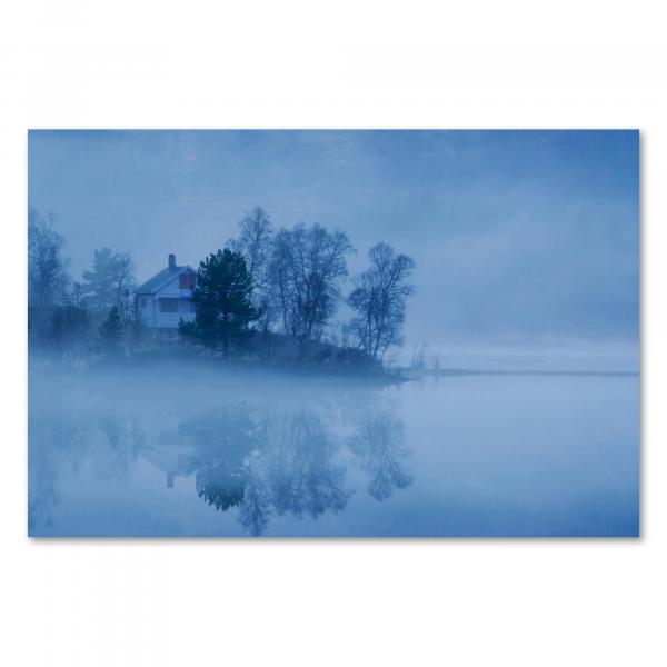 Ein einsames Haus am See, eingehüllt in dichten Nebel. Die Spiegelung im Wasser verstärkt die magische Stimmung.