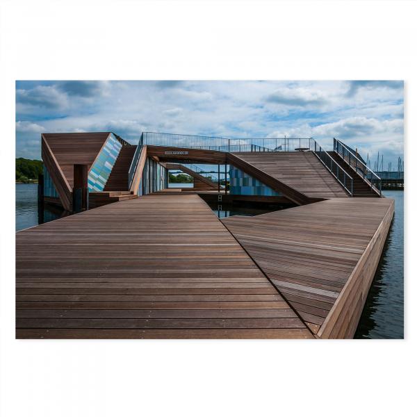 Moderner Holzsteg, blaues Gebäude, Rampen & Treppen, blauer Himmel & Wolken.