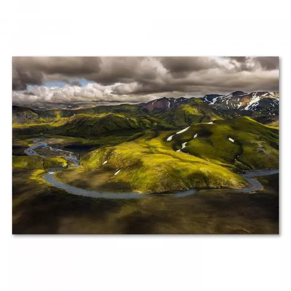 Luftaufnahme: Island, grüne Hügel, Fluss, Schneeberge im Hintergrund.