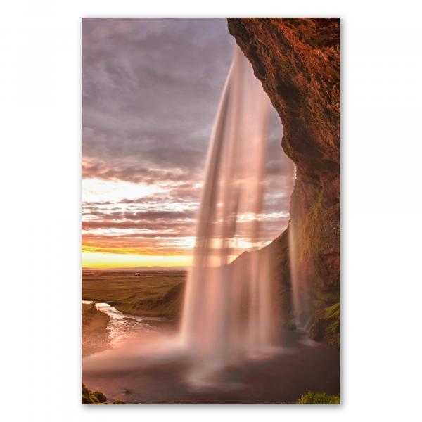 Mächtiger Wasserfall in Island erstrahlt im warmen Licht der untergehenden Sonne.