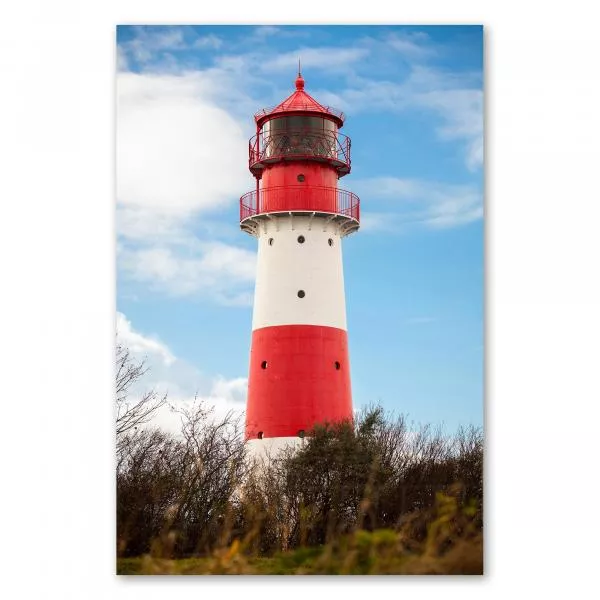 Ein rot-weisser Leuchtturm vor blauem Himmel - ein Symbol für Sicherheit und Orientierung.