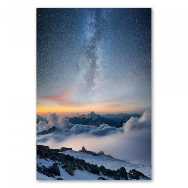 Milchstraße am Nachthimmel, schneebedeckte Berggipfel über Wolkenmeer.