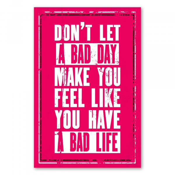 Motivationsspruch auf pinkem Hintergrund: „Don't let a bad day make you feel like you have a bad life“.