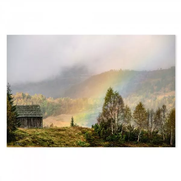 Ein bunter Regenbogen erstrahlt über einer Holzhütte in den Bergen, während Nebel die Landschaft bedeckt.