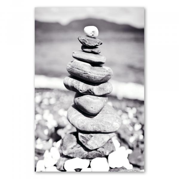 Ein Steinturm am Strand, eingefangen in einer zeitlosen Schwarz-Weiß-Fotografie – ein Symbol für Balance und Harmonie.