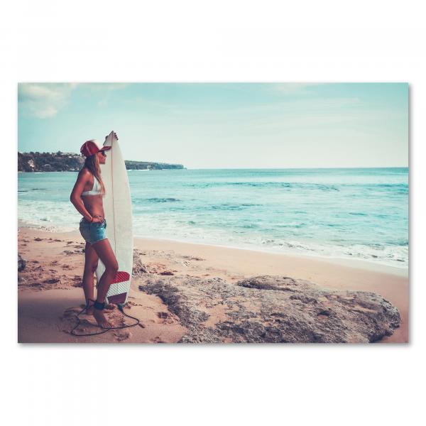 Surferin, Surfbrett, Strand, Blick aufs Meer, weißes Top, Jeans, Kappe.