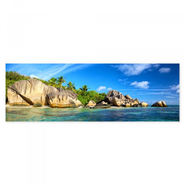 Traumstrand auf den Seychellen: Türkisblaues Wasser, Sand, Felsen & Palmen.