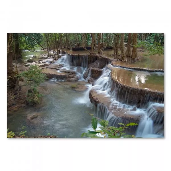 Mehrstufiger Wasserfall mit weichem Wasserfluss, umgeben von üppigem Grün und Bäumen.